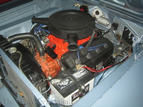 1968 Ford Mustang - Close-up view of a car's engine compartment, showing the engine block, air filter housing, and battery.