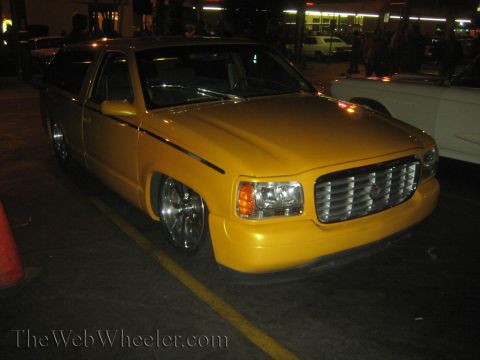 1968 Ford Mustang - A yellow pickup truck is parked on a street at night, with its front end visible.