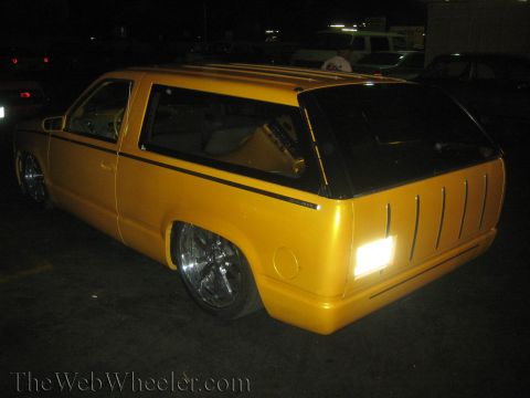 1968 Ford Mustang - Custom yellow SUV modified with chrome wheels and a unique rear end design, seen at night.