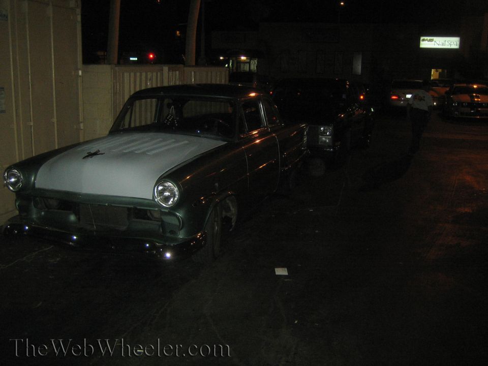 Dark green sedan with light grey hood, front view