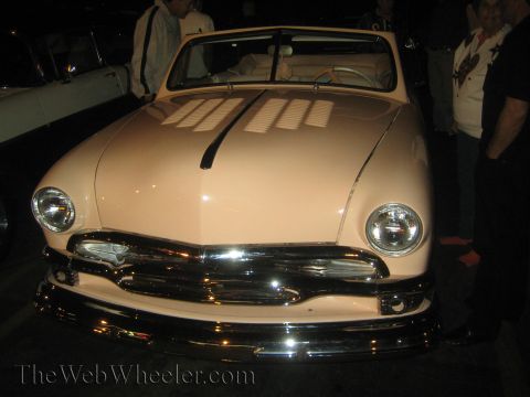 1968 Ford Mustang - This classic pink convertible features a prominent chrome grille and distinctive headlights.