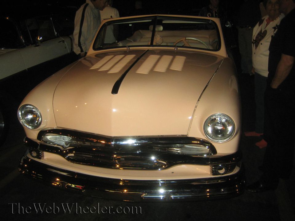 Pink convertible with chrome grille and headlights, front view