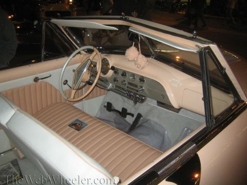 1968 Ford Mustang - Interior of a classic convertible with a tan and white color scheme, fuzzy dice hanging from the rearview mirror.