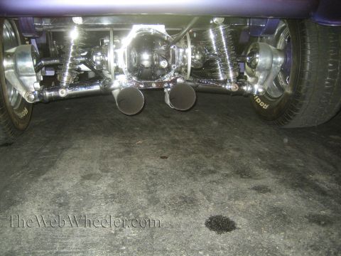 1968 Ford Mustang - The rear suspension and exhaust system of a custom vehicle are shown, with a chrome differential and dual exhaust pipes.