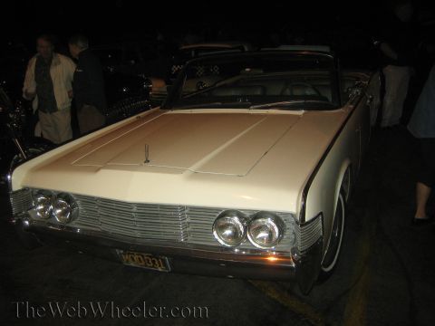 1968 Ford Mustang - This 1966 Lincoln Continental convertible features a distinctive grille and quad headlights, seen from the front.