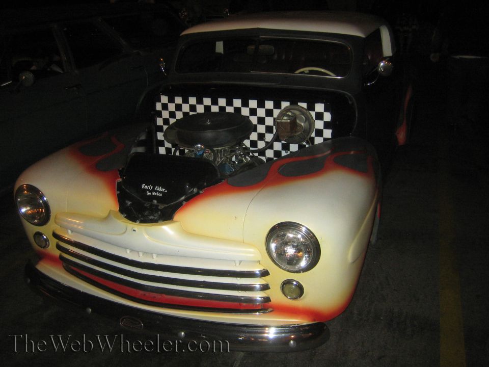 Custom hot rod with flames painted on the hood and checkerboard pattern on the firewall. Engine is visible