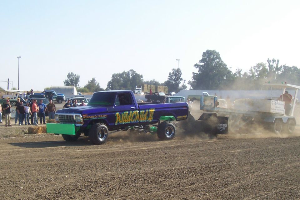 Purple pickup truck with 'Wild Child II' on the side, pulling a trailer