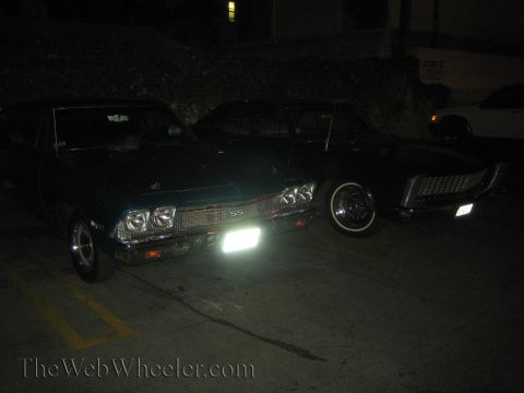 1968 Ford Mustang - Two vintage cars, a dark green 1969 Chevrolet Chevelle SS and another dark vehicle, are parked outdoors at night.