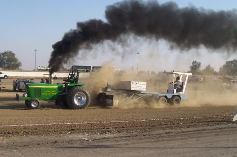 1994 Ford F-150 - A tractor competes in a pull, emitting a large cloud of black smoke.