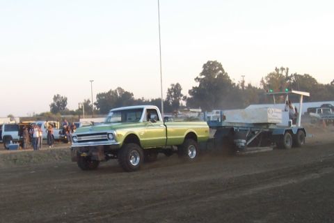 1994 Ford F-150 - A modified pickup truck is seen pulling a sled during an event, with spectators in the background.