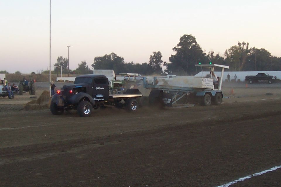 Black pickup truck with Snap-on logo towing a trailer on a dirt track