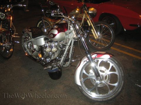 1968 Ford Mustang - A custom motorcycle with flame graphics is parked next to a red car and another motorcycle.