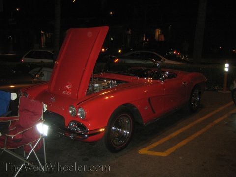 1968 Ford Mustang - A red convertible sports car is parked at night with its hood open, revealing the engine. A 40th anniversary sticker is visible on the hood.