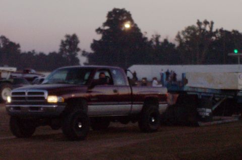 1994 Ford F-150 - This maroon pickup truck, likely a 1994 Dodge Ram, is seen from a 3q-front angle while towing a trailer.