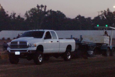 1994 Ford F-150 - White Dodge Ram pickup truck towing a trailer during dusk. The truck appears to be from the early 2000s.