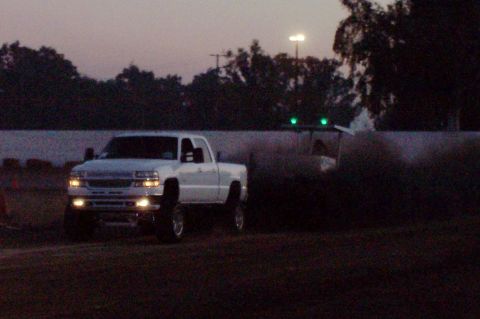 1994 Ford F-150 - A white pickup truck is seen from the front-right at dusk, with its headlights and fog lights on.