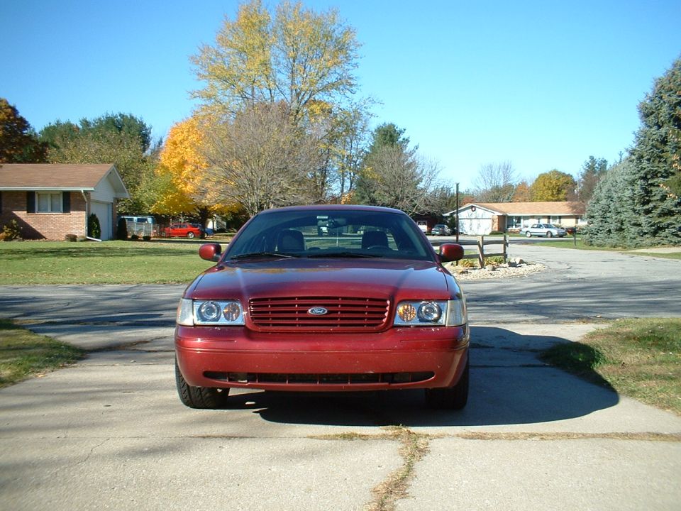 Front view of a dark red Ford Crown Victoria in a driveway