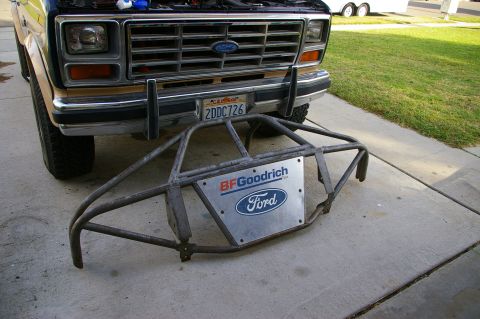 1986 Ford Bronco - A custom roll cage bumper with BFGoodrich and Ford logos sits in front of a classic Ford Bronco.