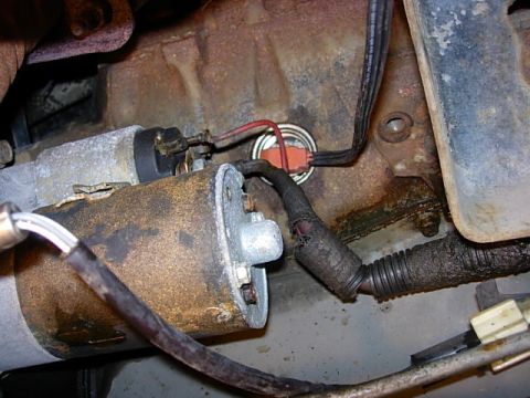 1993 Ford Bronco - Close-up view of a starter motor and engine block components, showing wear and tear.