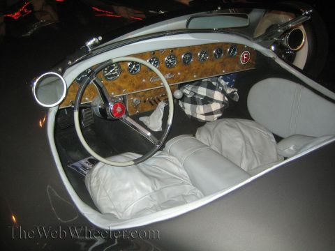1968 Ford Mustang - The interior of a classic car features a woodgrain dashboard with multiple gauges and a white steering wheel.