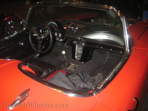 1968 Ford Mustang - The interior of a classic red convertible is visible, a detailed dashboard and steering wheel.
