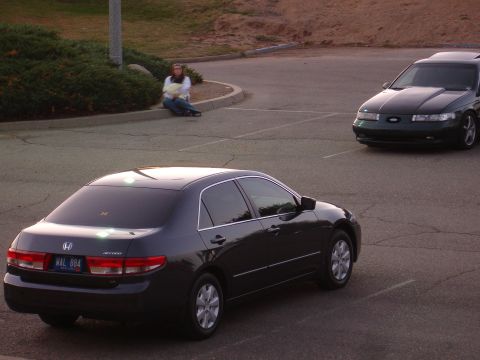 1993 Ford Taurus - A dark green 1993 Ford Taurus is parked in a lot, with another car in the foreground.