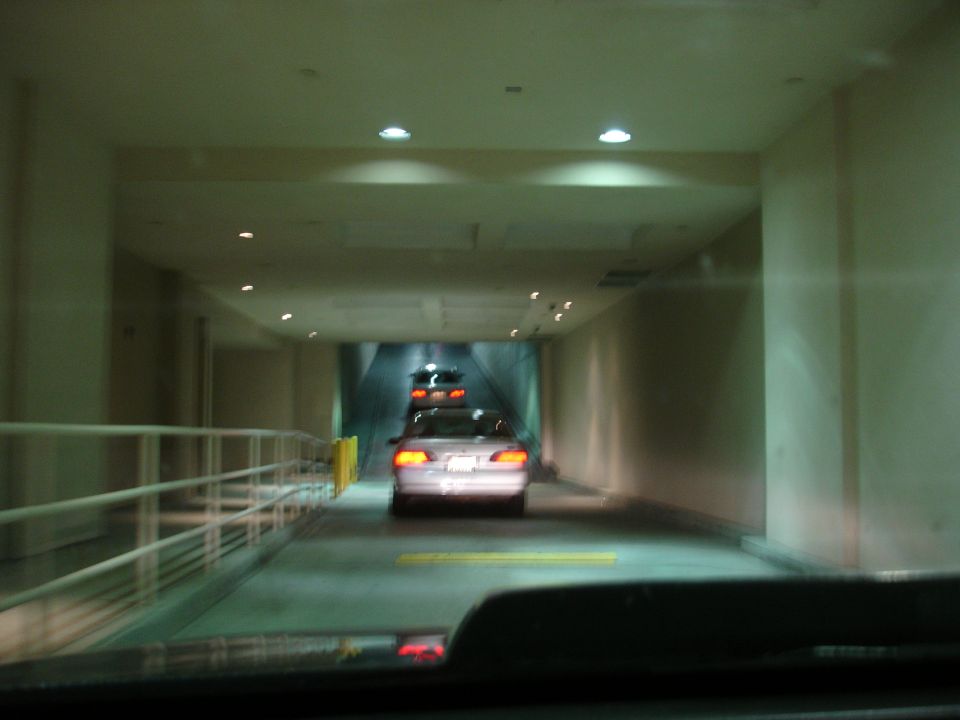 Silver sedan's rear view in a tunnel with another car behind it