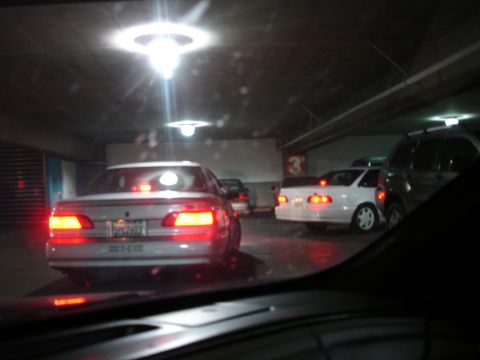 1993 Ford Taurus - Rear view of a 1993 Ford Taurus in a dimly lit parking garage, with multiple vehicles present.
