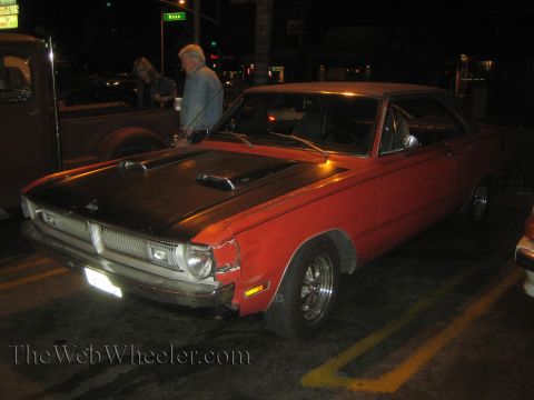 1968 Ford Mustang - This red Dodge Dart from the early 1970s has a black hood and a damaged front fender.