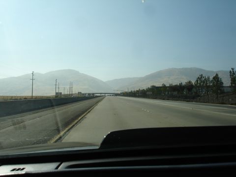 1993 Ford Taurus - View from a vehicle traveling on a highway, with mountains visible on the horizon under a clear sky.