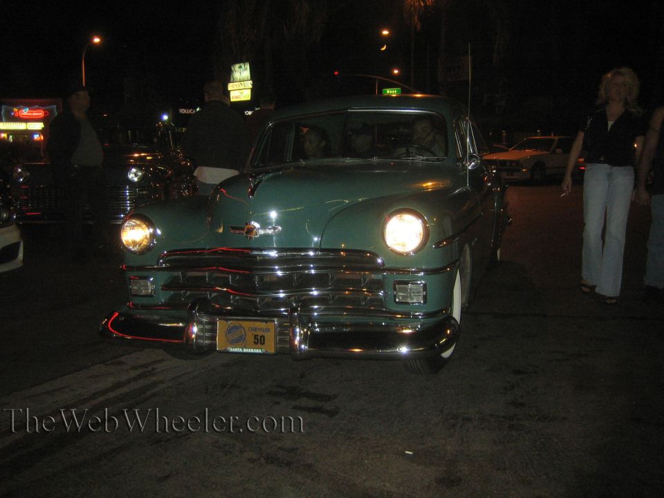 Green sedan with chrome grille and bumper, license plate reads '50'