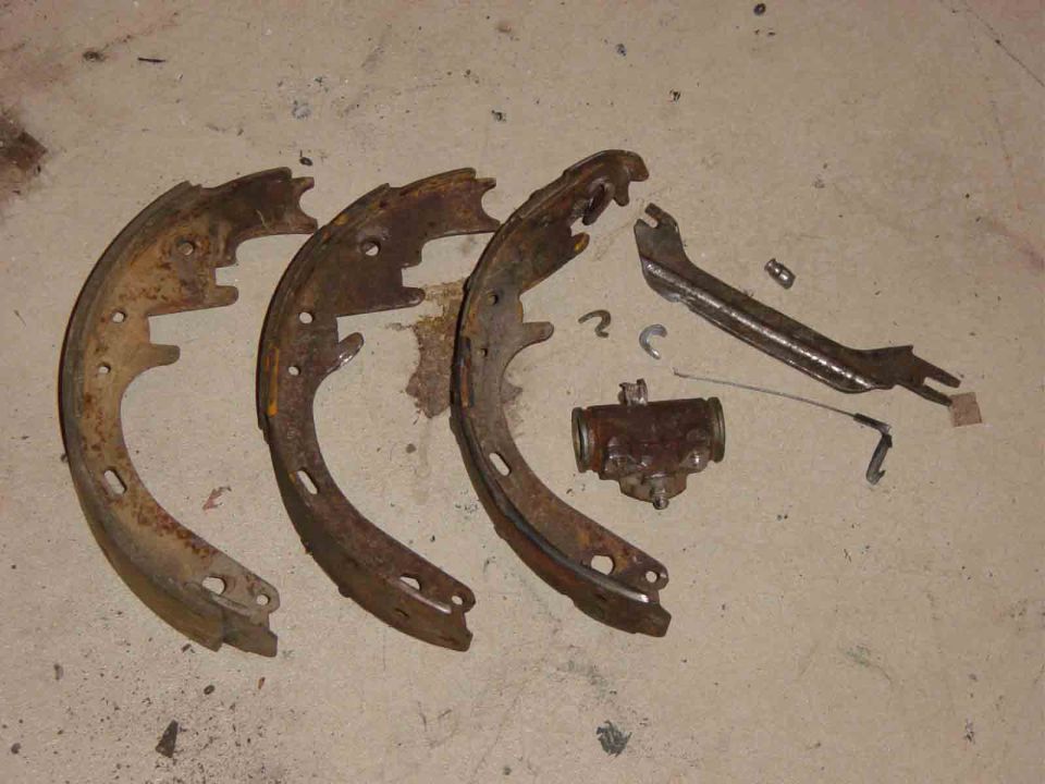 Used drum brake shoes, wheel cylinder, and springs on concrete floor