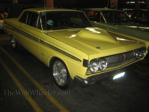 1968 Ford Mustang - A yellow 1964 Mercury Comet is parked indoors, a large hood scoop and custom wheels.