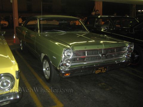 1968 Ford Mustang - This green Ford Fairlane from 1966 is parked next to other vehicles.
