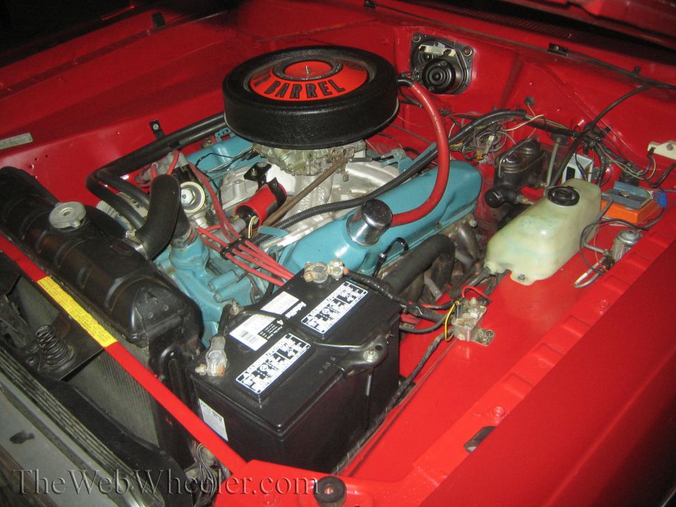 Red engine bay with a blue engine, black air cleaner with '2-BARREL' text, and a black battery