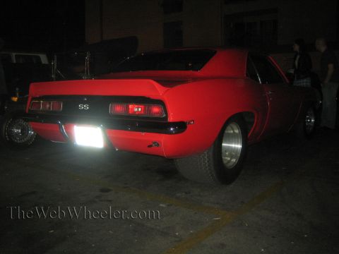 1968 Ford Mustang - Rear view of a red 1969 Chevrolet Camaro SS with a spoiler and wide rear tires.