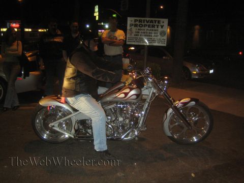 1968 Ford Mustang - A custom motorcycle with flame decals is parked at night, with people standing nearby and a private property sign in the background.