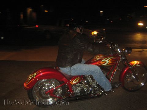 1968 Ford Mustang - A rider on a custom red motorcycle with flame graphics is seen from the side at night.