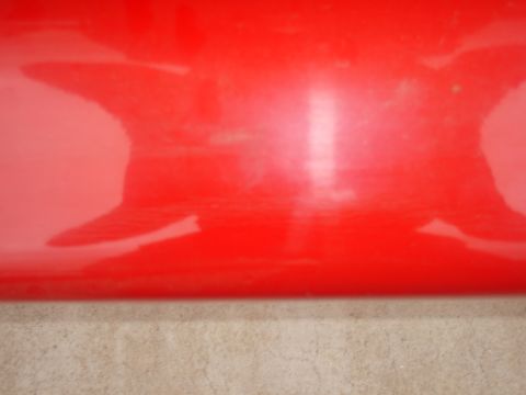 1997 Ford Probe - Close-up of a red car panel showing reflections and minor surface imperfections.