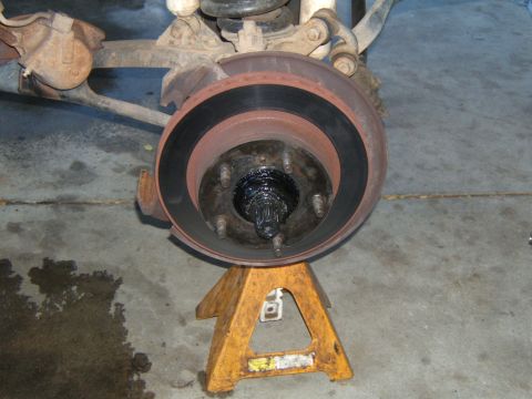 1988 Ford Bronco - Front wheel hub and brake rotor assembly on jack stand, ready for maintenance.