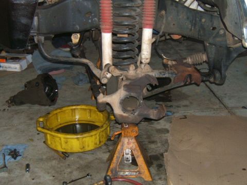 1988 Ford Bronco - Close-up of a vehicle's front suspension and differential during maintenance.