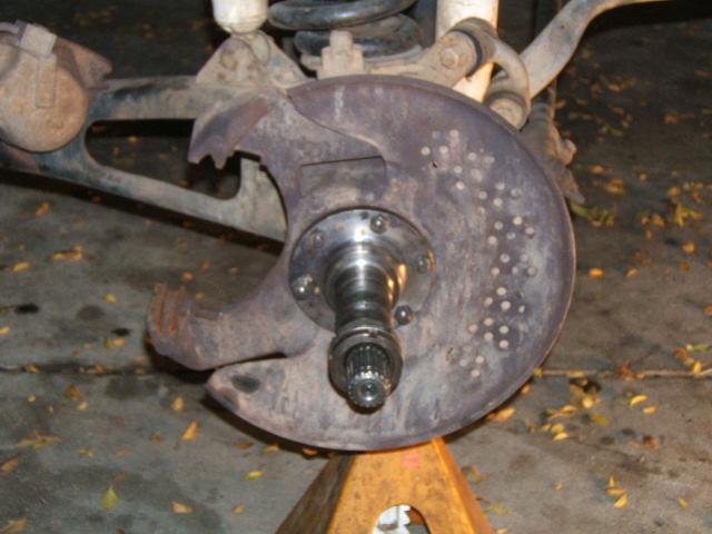 Front axle stub shaft and hub flange exposed at knuckle, truck on jack stand