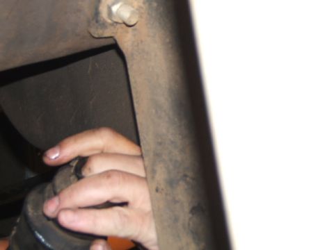 1988 Ford Bronco - A hand is shown adjusting a vehicle part, with rusty metal components visible in the background.