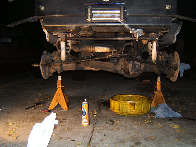 Front suspension and axle of a truck on jack stands, winch in bumper above