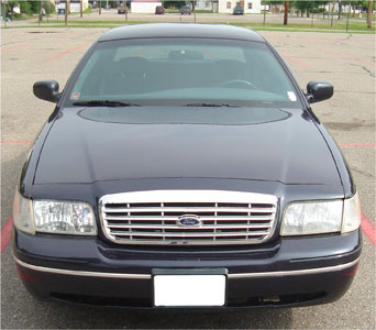1999 Ford Crown Victoria - This 1999 Ford Crown Victoria is seen from the front, its distinctive grille and Ford emblem.