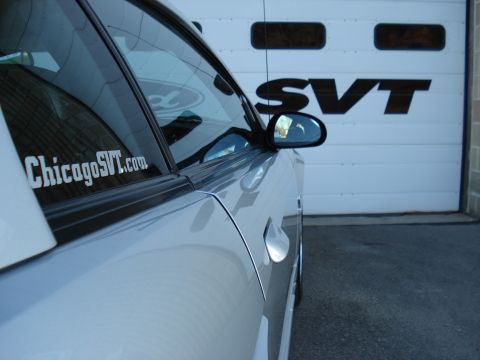 1998 Ford Taurus - Side view of a silver car with a ChicagoSVT.com sticker parked in front of a garage door displaying the SVT logo.