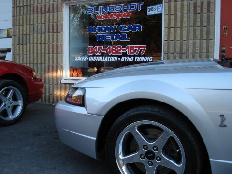 1998 Ford Taurus - Two cars are parked outside a business that offers show car detailing and dyno tuning.