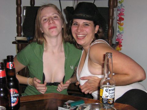 1995 Ford Bronco - Two women are posing at a table with beer bottles and a cigarette pack, with one woman lifting her shirt.