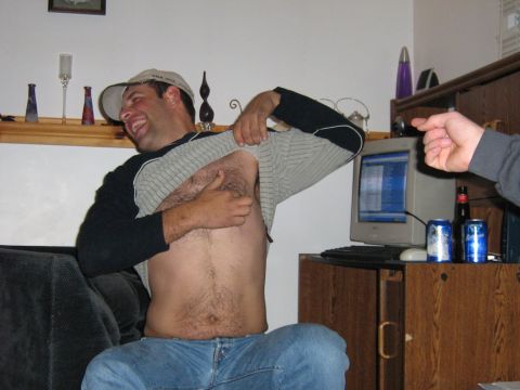1995 Ford Bronco - Man reveals chest hair while sitting on a couch next to a computer and drinks.