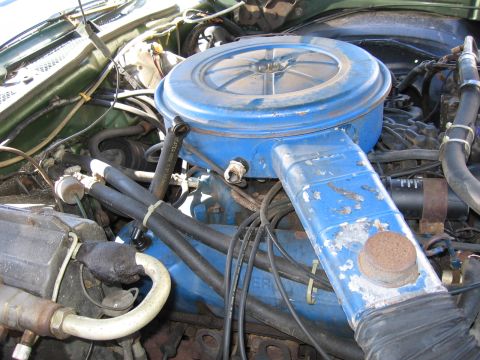1973 Ford Ranchero - The engine bay of a 1973 Ford Ranchero shows a blue air cleaner assembly and various hoses.